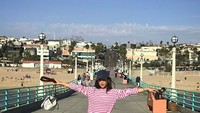 Saat liburan ke California, Anne berkunjung ke Pantai Manhattan. Gayanya kekinian banget ya! (cocoannne/ Instagram)