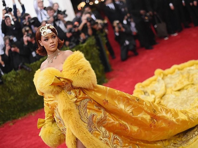 Rihanna memukau dengan gaun kuning model mantel berekor dramatis karya desainer China Guo Pei di MET Gala 2016. (Foto: Getty Images)