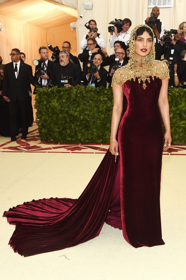 Priyanka Chopra menginjak karpet merah berbalut gaun velvet burgundy dari Ralph Lauren dan aksesori emas menutupi kepala hingga dada yang dibuat tangan selama 250 jam lebih. Foto: Getty Images