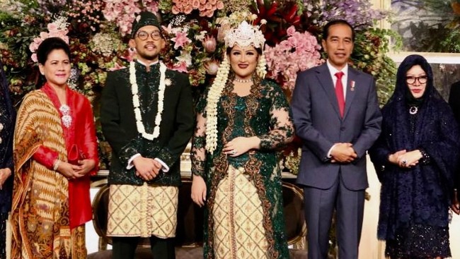 Di acara yang sangat penting, yaitu pernikahan putrinya, Mbak Tutut menambahkan selendang yang menjadi layer kedua hijabnya. Di layer pertama, ia tetap mengenakan hijab segi empat dengan gaya sederhana. Foto: Instagram/robbyray_yohannesbridal