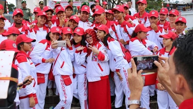 Saat pelepasan peserta Kirab Remaja Nasional di Sulawesi, Mbak Tutut kembali memilih hijab segi empat bermotif batik. Kali ini ia memilih warna merah sebagai dress code acara tersebut. Foto: Istimewa