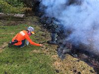 Seorang ahli geologi Observasi Gunung Berapi Hawaii (HVO) mengumpulkan sampel hujan rintik oleh celah 10 dari gunung berapi Kilauea, di Perkebunan Leilani di Hawaii,