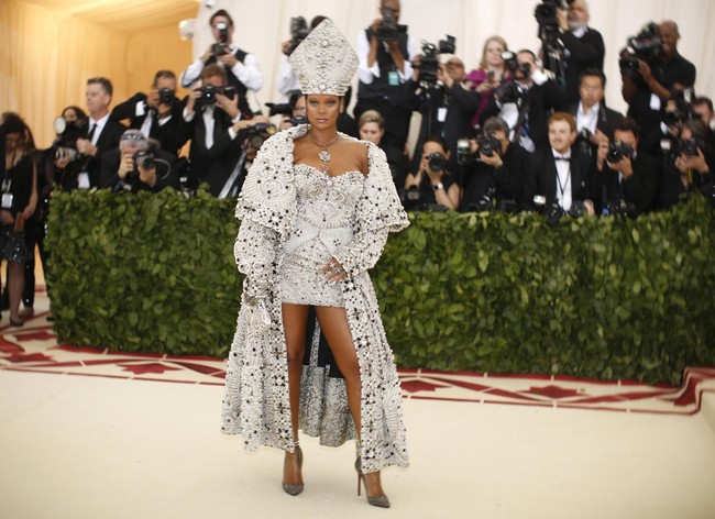 Met Gala 2018 berlangsung di Metropolitan Art Museum, New York City, Amerika Serikat (AS), Senin (7/5/2018) atau Selasa pagi WIB. Tahun ini, ajang yang dijuluki sebagai Oscar-nya insan mode dunia itu mengusung tema Heavenly Bodies: Fashion and the Catholic Imagination. Mendampingi Pemimpin Redaksi Vogue AS Anna Wintour sebagai tuan rumah (host), Rihanna tentu bergaya semaksimal mungkin. Pelantun ‘Umbrella’ itu tiba dengan sebuah fashion statement yang senada dengan temanya. Foto: Dok. Reuters, Getty Images