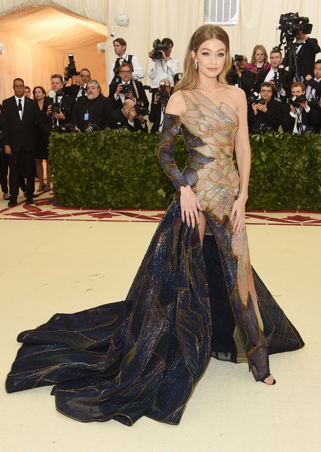 Gigi Hadid tampil berbalut gaun one-shoulder Versace yang menampilkan aksen kepingan kaca mosaik. Foto: Getty Images