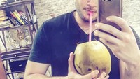 Sepertinya ia doyan makan sambil selfie. Lihat saja gayanya berselfie sambil menyeruput kelapa ijo ini. Foto: Instagram @ridho_rhoma