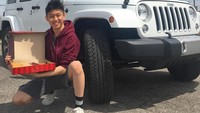 Di depan Jeep putih yang kelihatan gagah, Rich Brian jongkok memegang sekotak donat. Jadi mirip iklan donat ya? Foto: Instagram brianimanuel