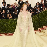 Rosie Huntington-Whiteley memikat bagai malaikat berbalut gaun emas dengan aksen cape dari Ralph Lauren. Foto: Getty Images