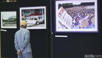 Pengunjung melihat foto-foto yang dipamerkan dalam kegiatan peringatan 20 Tahun Reformasi di Kompleks Parlemen, Senayan, Jakarta, Selasa (8/5/2018).