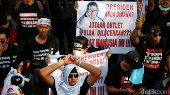 Para pedagang SIM card membawa atribut aksi seperti poster dan spanduk.