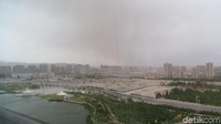 Yang kuning kecoklatan di langit itu bukan awan, tapi pasir terbang terbawa angin. Setelah 2 ribu tahun, Korla menjadi kota dengan gedung bertingkat dan jalanan lebar (Fitraya/detikTravel)
