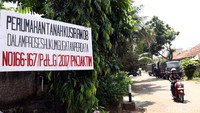 Papan bertuliskan Perumahan Tanah Kusir RW 08 Dalam Proses Hukum Gugatan Perdata terpampang di jalan masuk kompleks.