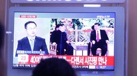 Warga Korea Selatan menyaksikan televisi yang menyiarkan berita tentang kunjunganKim-Jong-un ke Cina. (Foto: Dok. Reuters via BBC)