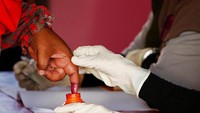 Seorang warga memasukkan jarinya ke tinta usai memilih. Reuters/Lai Seng Sin.