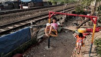 Anak-anak bermain di taman bermain pinggir rel kereta api, Kampung Bahari, Tanjung Priok, Jakarta Utara, Selasa (8/5/18).