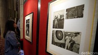 Pengunjung melihat foto yang dipamerkan.