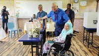 Pada pemilihan umum hari ini, Perdana Menteri Malayasia, Najib Razak, mengajak serta ibunda untuk menggunakan hak suara bersama di Pekan, Pahang, Malaysia. Athit Perawongmetha/Reuters.