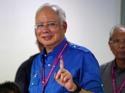 PM Najib memamerkan jari telunjuknya yang telah dicelupkan ke tinta usai memilih