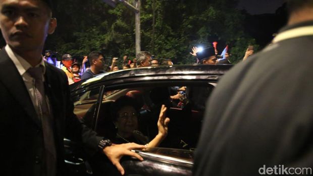 Mahathir dan dan istrinya melambaikan tangan dari dalam mobil kepada para pendukung