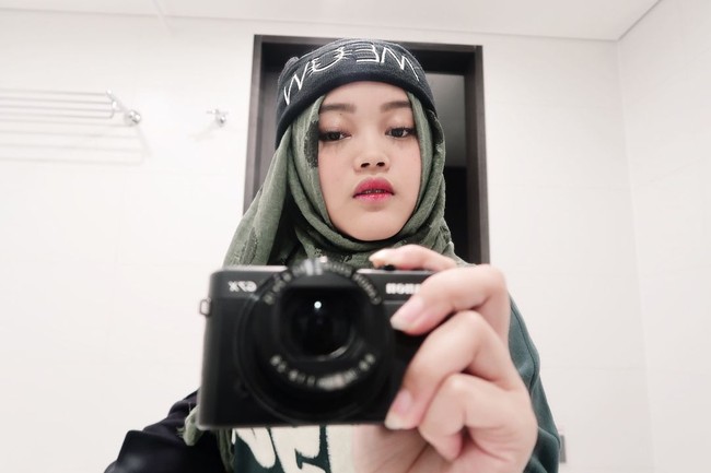 Berusia remaja, Putri Delina yang baru 18 tahun berusaha tampil kekinian dengan memadukan hijab dan topi. Foto: Dok. Instagram Putri Delina