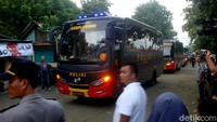 Rombongan bus pengangkut tahanan dikawal ketat anggota kepolisian.