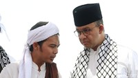 Anies ke Monas mengenakan baju koko warna putih dan peci hitam. Anies yang memakai syal berbendera Palestina dan Indonesia juga naik ke panggung dan berorasi.