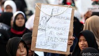 Terlihat seorang anak membawa spanduk membela Palestina.