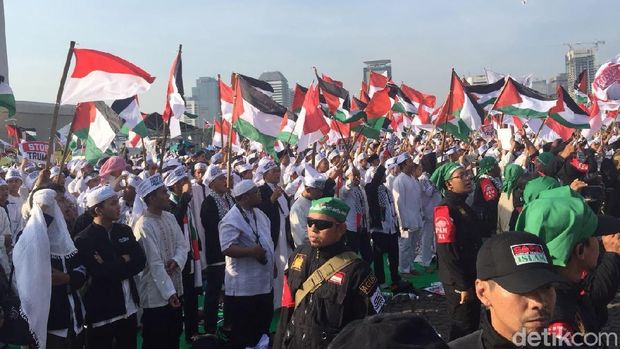 Massa membawa atribut aksi seperti bendera Palestina