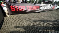 Massa membentangkan spanduk bertuliskan Stop Trump ! We Stand With Baitul Maqdis.
