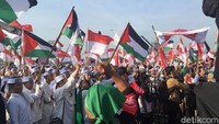 Massa berkumpul di depan panggung utama di Pintu Barat Laut Monas, Jumat (11/5/2018). Massa yang memutihkan kawasan Monas itu antusias mengibarkan bendera Indonesia dan Palestina. Selain bendera tampak sejumlah massa memegang poster bertuliskan Stop Trump. Fotografer: Ibnu Hariyanto/detikcom