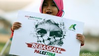 Seorang anak kecil membawa spanduk bertuliskan Bebaskan Palestina pada Aksi 115 di Monas, Jumat (11/5/18).