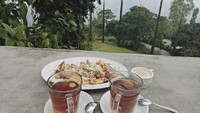 Kalau netizen ini kayaknya udah liburan duluan nih. Minum teh ditemani pisang goreng tabur keju. Latarnya pemanadangan alam yang asri. Foto : instagram @putrymerdeka