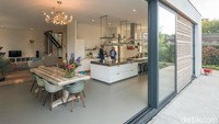 Lantai dasar rumah diperpanjang untuk membuat ruang untuk dapur terbuka dan area tempat duduk, yang mengarah ke luar melalui pintu geser kaca yang sangat besar. Foto: Inhabitat.com