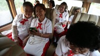 Para lansia berseragam menaiki bus sekolah. Mereka benar-benar kembali bersekolah. (Athit Perawongmetha/Reuters)