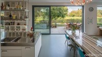 Di bagian interior, tangga kaca baru yang mengarah ke lantai atas dipasang untuk menyempurnakan denah lantai rumah yang terbuka. Foto: Inhabitat.com