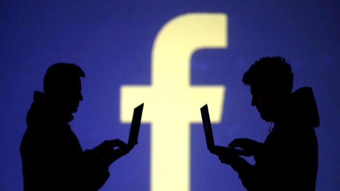 FILE PHOTO: Silhouettes of laptop users are seen next to a screen projection of Facebook logo in this picture illustration taken March 28, 2018.  REUTERS/Dado Ruvic/Illustration/File Photo                         GLOBAL BUSINESS WEEK AHEAD