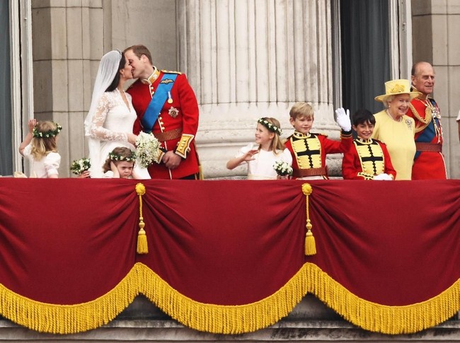 Disaksikan puluhan juta pasang mata di seluruh dunia, Pangeran William mencium belahan jiwanya di balkon Istana Buckingham, tanpa menghiraukan kehadiran neneknya, Ratu Elizabeth II. Momen tersebut semakin viral berkat kemunculan anak perempuan yang berdiri di depan sejoli ini dengan wajah menggerutu. (Foto: Getty Images)
