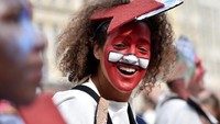 Penari lainnya terlihat mewarnai wajahnya saat sedang menari memeriahkan Parade Zinneke. Eric Vidal/Reuters.