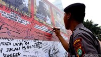 Seorang anggota polri ikut membubuhkan tanda tangan.