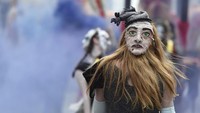 Seorang penari menggunakan topeng dua wajah sedang menampilkan tarian pada Parade Zinneke di Brussel, Belgia. Eric Vidal/Reuters.