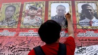 Seorang warga tampak membubuhkan tanda tangan sebagai ungkapan duka untuk para anggota Polri yang gugur saat rusuh di Mako Brimob, beberapa hari yang lalu.