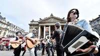 Terlihat kelompok musik dengan menggunakan kostum unik sedang memainkan musik untuk mengiringi para penari. Eric Vidal/Reuters.