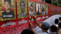 Warga ramai-ramai membubuhkan tanda tangan sebagai ungkapan duka.