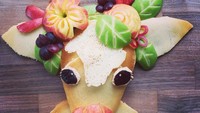 Kalau biasanya pancake berbentuk bulat. Kali ini Mazzei membuatkan anaknya pancake dengan bentuk anak sapi. Dengan hiasan mahkota bunga yang dibuat dari ragam buah seperti apel hijau, aple merah dan juga anggur. Foto: Instagram @foodartfun