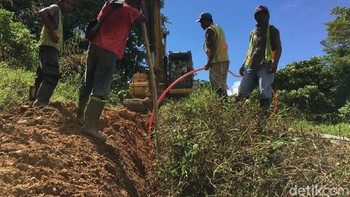Meski di tengah Matahari terik yang menyengat dan hewan sejenis lalat mengganggu, penggelaran kabel tetap dilakukan. Foto: Agus Tri Haryanto/detikINET