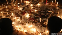 Lilin dinyalakan dan diletakkan di lantai Tugu Pahlawan sebagai simbol duka untuk korban dan perlawanan terhadap aksi teror. (Foto: Suryaman Candi/detikcom)