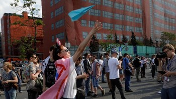 Salah satu pendemo wanita menerbangkan kertas pesawat sebagai bentuk demo kepada pemerintah. (Foto: Reuters/Tatyana Makeyeva)