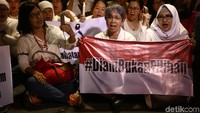 Massa membentangkan spanduk bertulisan Diam Bukan Pilihan.
