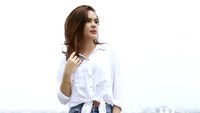 Ia tampil boyish dengan ripped jeans dan kemeja putih. 