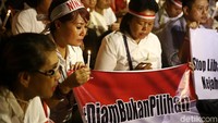 Massa menyalakan lilin dan bernyanyi Bagimu Negeri.