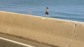 Wanita ini terlihat berlari di atas pembatas jalan. (Foto: Brightside)